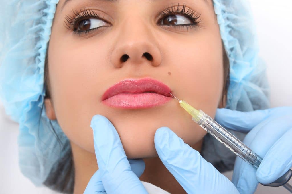 woman receiving injection of lip filler