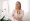 Beautiful mature woman admiring her reflection in the mirror while sitting at dressing table at home, attractive middle aged female touching her smooth skin with joy, enjoying domestic beauty routine