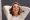 Close up portrait older woman smiling with hand in hair